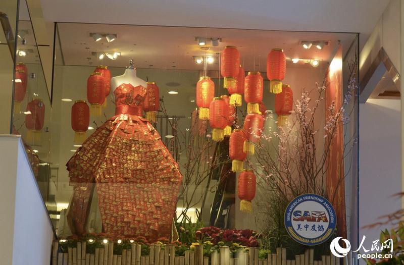 “步步高升中國紅”櫥窗中一條由紅包制成的禮服吸引人們的目光。 圖片由美中友好協會提供