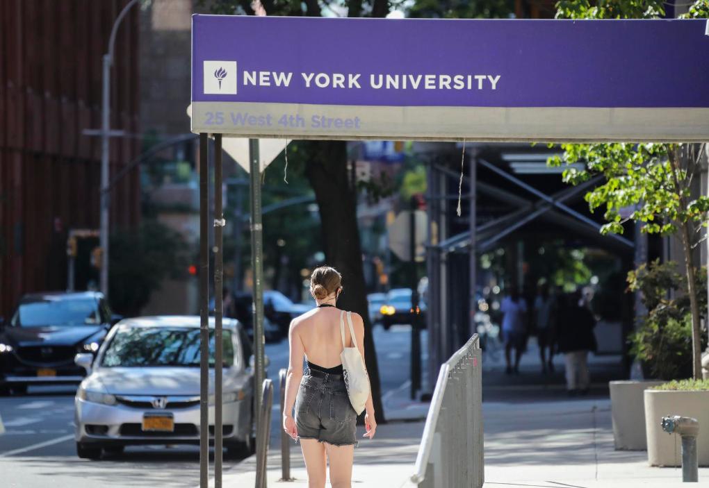 2020年7月14日，一名女子从美国纽约大学的教学楼前走过。新华社记者王迎摄