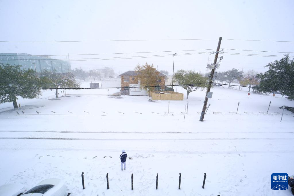 1月21日，在美国路易斯安那州新奥尔良，一名男子站在受暴风雪袭击的街道上。新华社发（魏兰摄）