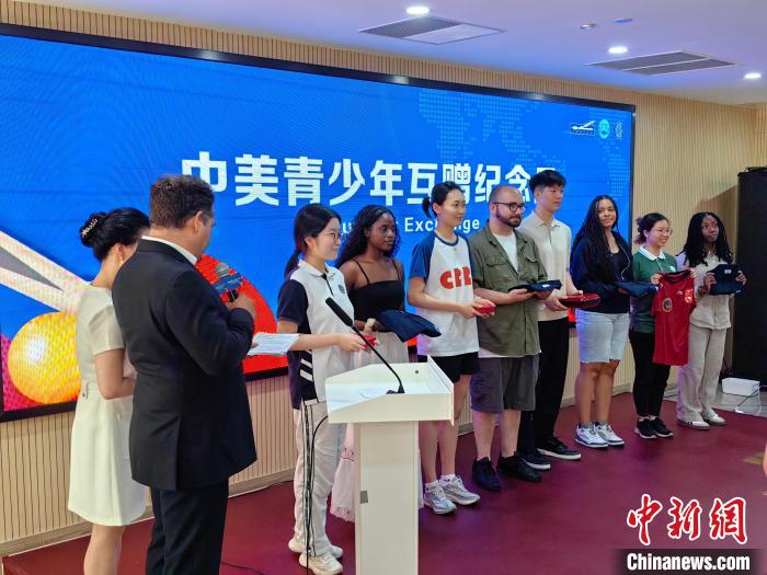 6月16日，“小球大爱”——纪念中美“乒乓外交”暨青少年乒乓交流活动在上海举行。图为中美青少年互赠纪念品。　范宇斌 摄