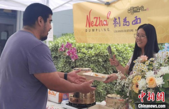 美国时间6月1日，在美国洛杉矶帕萨迪纳市“NeZha　Dumpling”门店的门口，嵊州小笼包吸引当地民众购买和品尝。(受访者供图)
