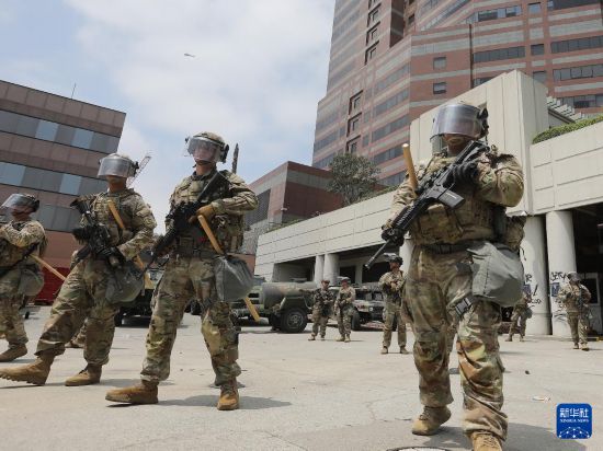 6月8日，國民警衛隊人員在美國加利福尼亞州洛杉磯市中心的聯邦執法機構門前警戒。新華社發（邱晨攝）
