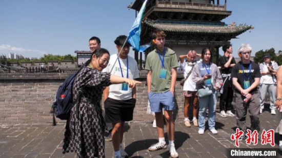 美国青年登上平遥古城墙。平遥县融媒体中心 提供