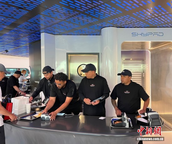 图为特斯拉首家超级充电站餐厅内，服务员给顾客准备餐食，食盒是特斯拉电动车造型。中新社记者 张朔 摄