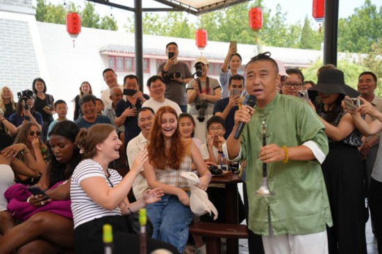 8月9日，河北沧州，非遗传承人何树森的唢呐表演令外国青年们惊叹不已。（宋可柠 摄）