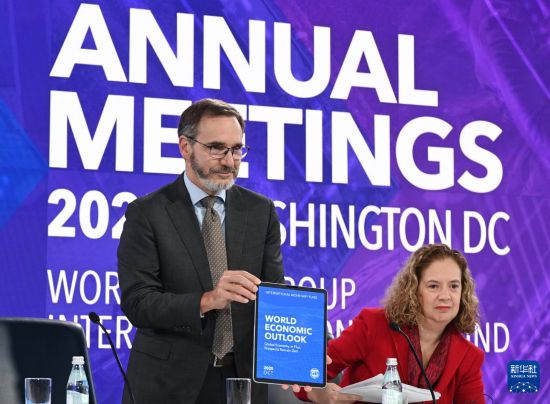 10月14日,在美國華盛頓,國際貨幣基金組織首席經濟學家皮埃爾-奧利維耶·古蘭沙(左)在《世界經濟展望報告》新聞發布會上展示報告。新華社記者 李睿 攝