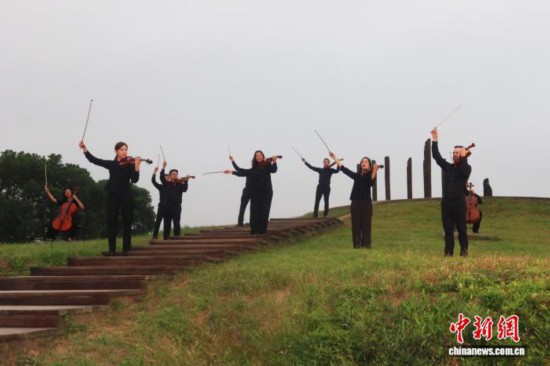 10月14日,费城交响乐团的成员们在杭州良渚古城遗址公园内的小莫角山演奏《梁祝》。孙琳茹 摄