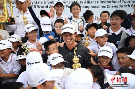 10月19日，中国青少年高尔夫慈善盛典暨副省级城市联盟邀请赛在四川省成都市青城山举行，来自美国的高尔夫球名将科林·森川亮相球场，并与参赛的青少年一起挥杆、交流。科林·森川的妻子朱凯琳籍贯四川成都，作为“四川女婿”，这也是他首次来到成都。图为科林·森川与青少年高尔夫球运动员合影。中新社记者 张浪 摄
