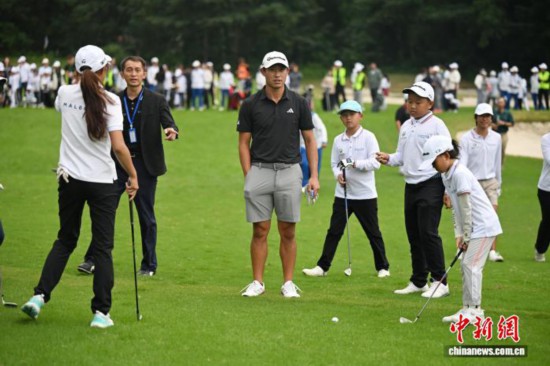 图为科林·森川在球场上和青少年高尔夫球运动员互动交流。中新社记者 张浪 摄