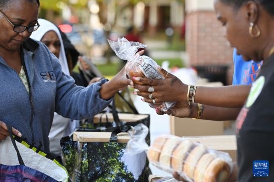 10月21日，在美国马里兰州海厄茨维尔市，联邦雇员领取免费食品。新华社记者 李睿 摄