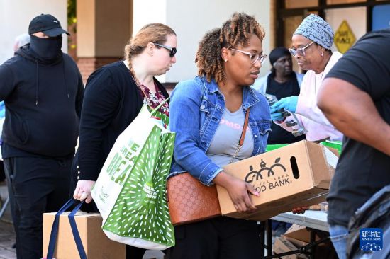 10月21日，在美国马里兰州海厄茨维尔市，联邦雇员领取免费食品。新华社记者 李睿 摄
