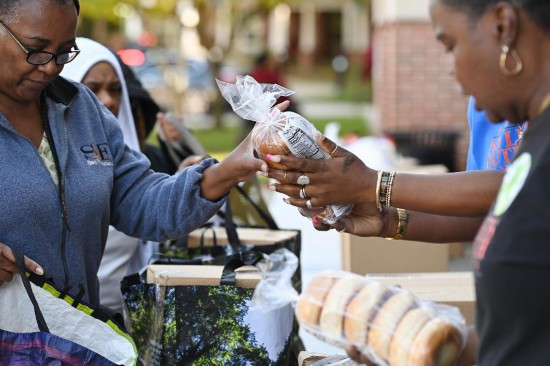 10月21日,在美国马里兰州海厄茨维尔市,联邦雇员领取免费食品。新华社记者李睿摄