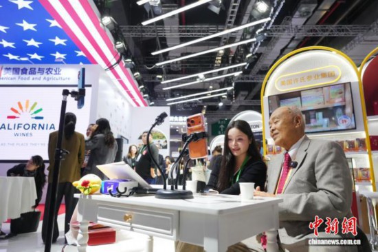 11月6日，美国食品与农业馆在第八届进博会上举行开馆仪式。19家参展商涵盖了美国农产品生产商、州政府及食品协会，展示了美国农业及食品产业在质量、安全和创新方面的领先优势。图为美国许氏花旗参创始人许忠政(右)直播带货。中新社记者 张亨伟 摄
