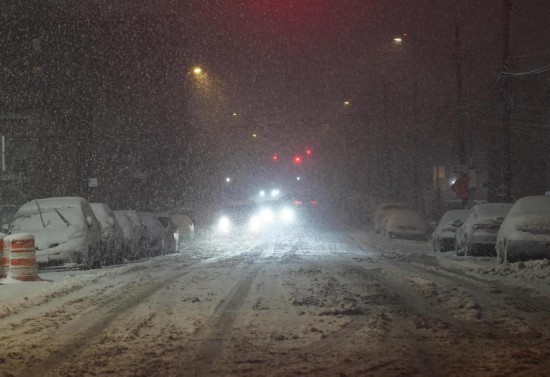 2月22日，在美国纽约，车辆在雪中缓慢行驶。新华社记者张凤国摄