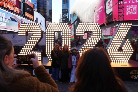2025年12月22日，在美国纽约时报广场，游客在2026年数字牌前留影。新华社记者张凤国摄